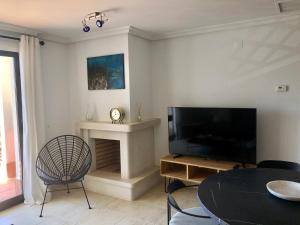 a living room with a flat screen tv and a chair at Praia da Falésia - Falesia Beach - Apartment Netflix and HBO in Albufeira