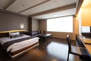 a bedroom with a bed and a large screen at Bourou Noguchi Hakodate in Hakodate