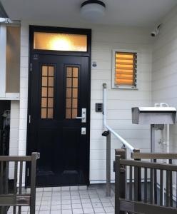 Yokohama - House - Vacation STAY 9002 في يوكوهاما: باب أسود على جانب المنزل