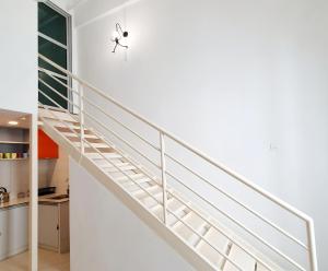 eine Treppe in einem Haus mit weißen Wänden in der Unterkunft Explore The World at The CEO Studio Penang - Netflix in Bayan Lepas