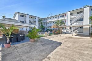 a large apartment building with a courtyard with palm trees at Cocos Holiday Apartments in Trinity Beach