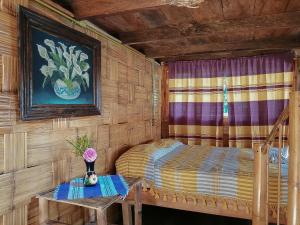 niewielka sypialnia z łóżkiem i stołem w obiekcie Cabañas Los Achicuales w mieście Cuetzalan del Progreso