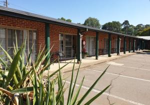 a red brick building with a row of windows at Murrumbateman Country Inn in Murrumbateman