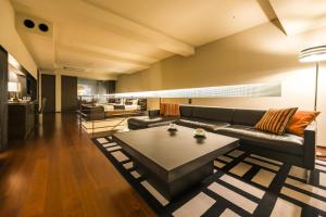 a living room with a couch and a coffee table at Bourou Noguchi Hakodate in Hakodate