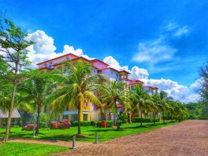 a row of palm trees in front of a building at Le'Coco Homestay Tiara Desaru Pool View in Desaru