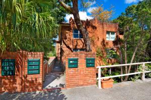 a brick house with green doors and a fence at HIGH5NS - Haven on High in Sydney