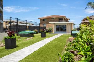 a garden area with a lawn and lawn chair at Burleigh Esplanade Apartments in Gold Coast