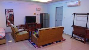 a living room with two chairs and a television at DD Empire Homestay in Kuala Selangor