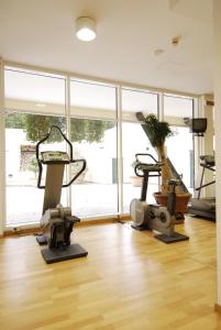 un gimnasio con dos máquinas de correr y una gran ventana en Park Hotel Ripaverde, en Borgo San Lorenzo
