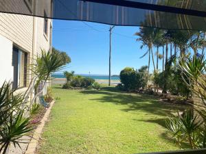 a yard with a view of the ocean from a house at Dolphin View on South Esplanade in Bongaree