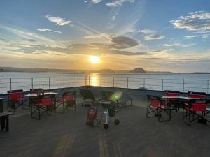 a deck with tables and chairs at sunset on a ship at Sea Style Resort OCEAN in Karatsu