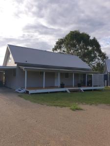a large white building with a white roof at Madigan Wine Country Cottages in Lovedale