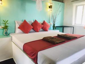 a bedroom with two beds with red and white pillows at Bohemiaz Resort and Spa Kampot in Kampot