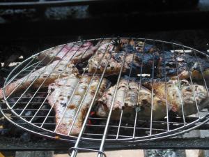 a bunch of food cooking on a grill at Appartement dans Villa avec jardin et piscine pour détente et évasion in Montjoly