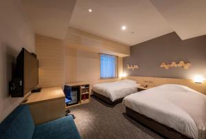 高知市にあるJRクレメントイン高知のベッド2台、薄型テレビが備わるホテルルームです。