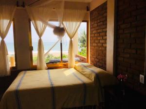 een slaapkamer met een bed en een groot raam bij Ananda Guest House Yoga & Meditación in Puerto Escondido
