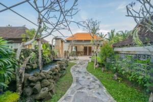 una pasarela frente a una casa con un arroyo en Sweet Orange Pondok, en Ubud