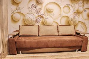 a couch in a room with a wall with plates at Molex Apartments 3 in Chernihiv