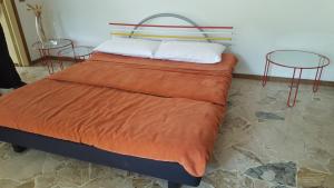 a bed with two chairs and an orange blanket at Civico 17 in Canzo