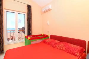 sypialnia z czerwonym łóżkiem i oknem w obiekcie Top of the Tops Center Apartment, best sea view in town w Splicie