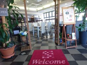 a restaurant with a welcome mat on a checkered floor at Terminal Hotel Matsuyama in Matsuyama