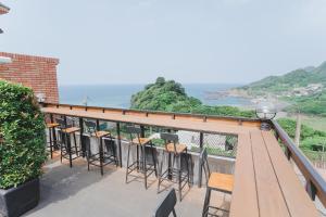 a balcony with chairs and a view of the ocean at Rose Villa in Ruifang