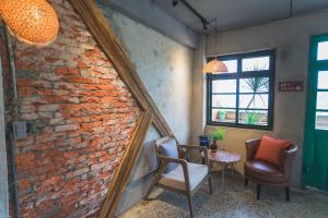 a mirror leaning against a brick wall with two chairs and a table at Rose Villa in Ruifang