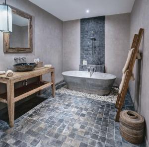 a bathroom with a tub and a sink at MATHIS Retreat Ubud in Ubud