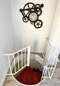 a clock on the wall next to a staircase at Spiral Stairs Duplex in Figueres