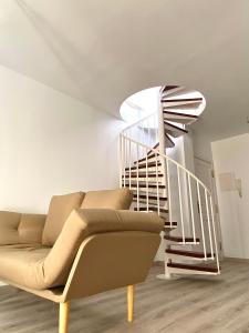 ein Wohnzimmer mit einem Sofa und einer Treppe in der Unterkunft Spiral Stairs Duplex in Figueres