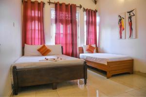 two beds in a room with red curtains at Inroma Holiday Resort in Nuwara Eliya