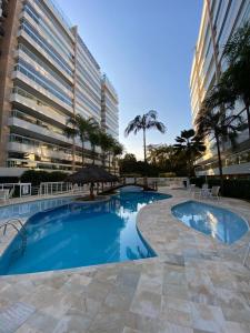 里維埃拉德聖洛倫索的住宿－Apartamento Alto Padrão - Home Resort Laguna，大型建筑前的大型游泳池