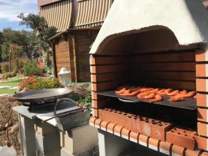 piec ceglany z hot dogami na grillu w obiekcie Cabaña rústica w mieście Collado-Villalba