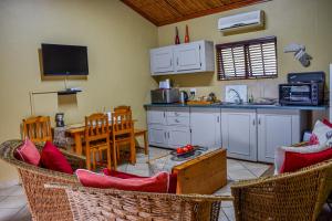 une cuisine avec des chaises, une table et un comptoir dans l'établissement African Spirit Game Lodge, à Manyoni Private Game Reserve