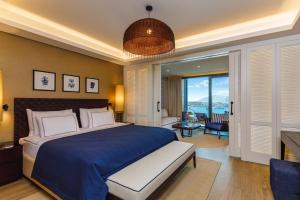 a bedroom with a large bed and a living room at Kaya Palazzo Resort & Residences Le Chic Bodrum in Bodrum City