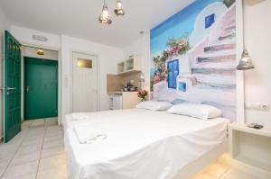 a bedroom with a large white bed with a painting on the wall at simos luxury apartments in Naxos Chora
