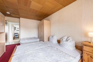 Un dormitorio con una cama con almohadas blancas. en Haus Schild, en Grassau