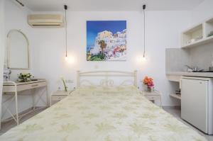 a white bedroom with a bed and a sink at simos luxury apartments in Naxos Chora