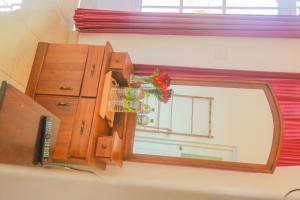 a mirror on a wall next to a dresser at Inroma Holiday Resort in Nuwara Eliya +28 photos