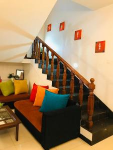 a living room with a couch with colorful pillows at Inroma Holiday Resort in Nuwara Eliya