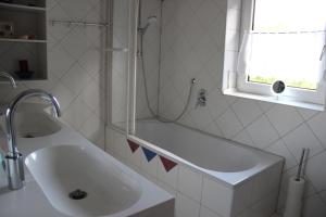 ein weißes Bad mit einem Waschbecken und einer Dusche in der Unterkunft Ferienwohnung Christine Trautner in Gößweinstein