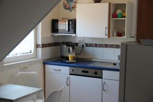 eine Küche mit weißen Schränken und einer blauen Arbeitsplatte in der Unterkunft Ferienwohnung Christine Trautner in Gößweinstein