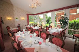 a dining room with tables and chairs and windows at Hotel-Garni Haus Johanna in Einbeck