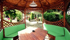 um gazebo com uma mesa de madeira e cadeiras verdes em Hotel-Garni Haus Johanna em Einbeck