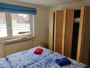 a bedroom with a bed with two red pillows on it at Haus Trossenstek I in Büsum