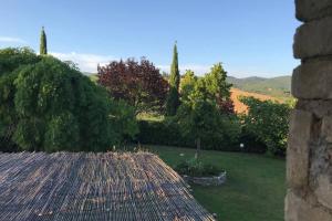 vistas a un jardín con árboles y un techo en Premiere Apartments - Residenza Le Rose nel Chianti, en Lornano
