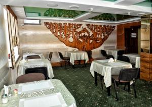 a dining room with two tables and a chandelier at Green City Hotel in Mykolaiv