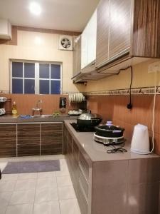 - une cuisine avec des placards en acier inoxydable et une cuisinière dans l'établissement Green Hill Resort Tanah Rata 3R2B WiFi, à Tanah Rata