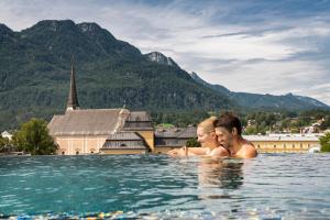 Ein Mann und eine Frau im Wasser im Pool in der Unterkunft EurothermenResort Bad Ischl - Hotel Royal 4-Sterne Superior in Bad Ischl