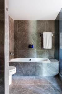 a bathroom with a tub and a toilet at Radisson Blu Hotel, Madrid Prado in Madrid